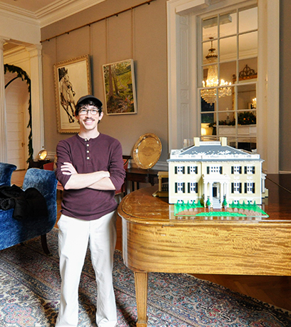 Benjamin Edlavitch đang đứng với mô hình LEGO của Tòa nhà điều hành.