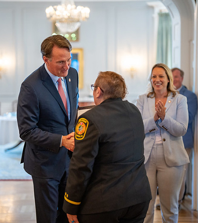 Thống đốc bắt tay với một người ứng phó khẩn cấp